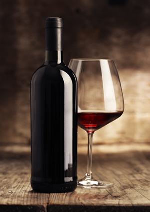 Wine bottles with glass, wooden background